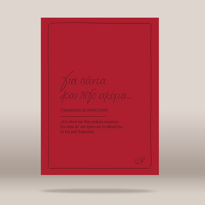 A red greeting card with black Greek text and a thin black border, shown standing upright against a neutral light gray background.