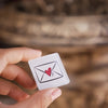 Hand holding a small card with a heart and envelope symbol against a blurred background