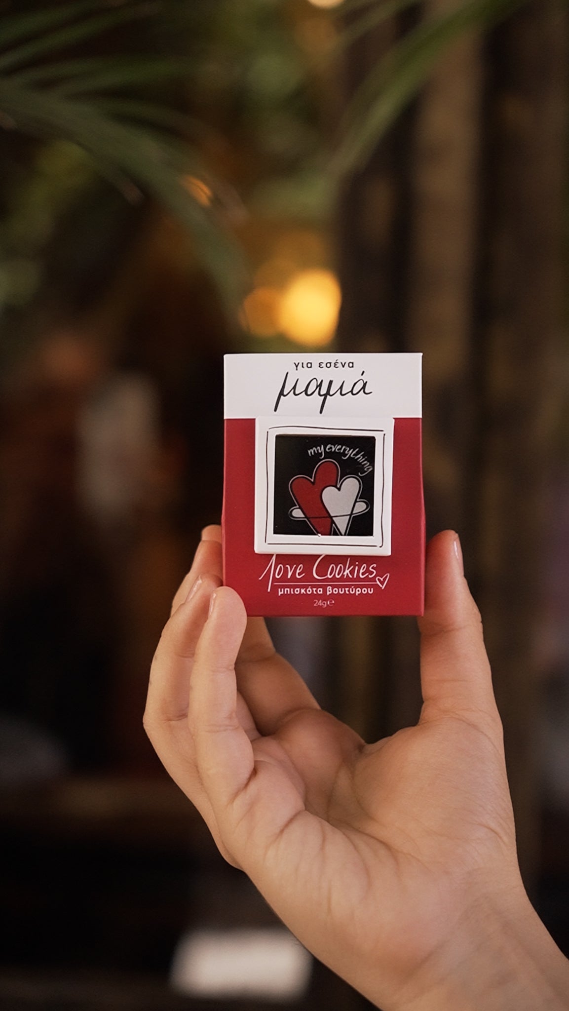 Hand holding a small red box with 'Pipia' branding against a blurred background