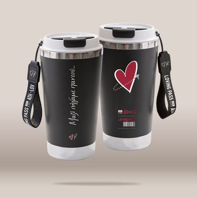 Two black insulated travel tumblers with white lids and carrying straps, shown from front and back against a plain beige background. The front tumbler has a red heart graphic and white Greek text, while the back tumbler shows red and white text and barcode-style graphics.
