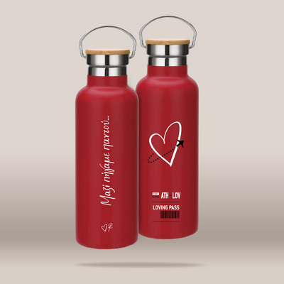 Two red insulated water bottles with bamboo-look screw tops and metal carabiner handles, shown on a plain beige studio background. One bottle has white script text reading 'Mostrique paris.