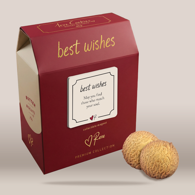 A red gift box with gold lettering reading 'best wishes' and 'Pene Premium Collection' on a light beige background, with two round butter cookies placed in front of the box.