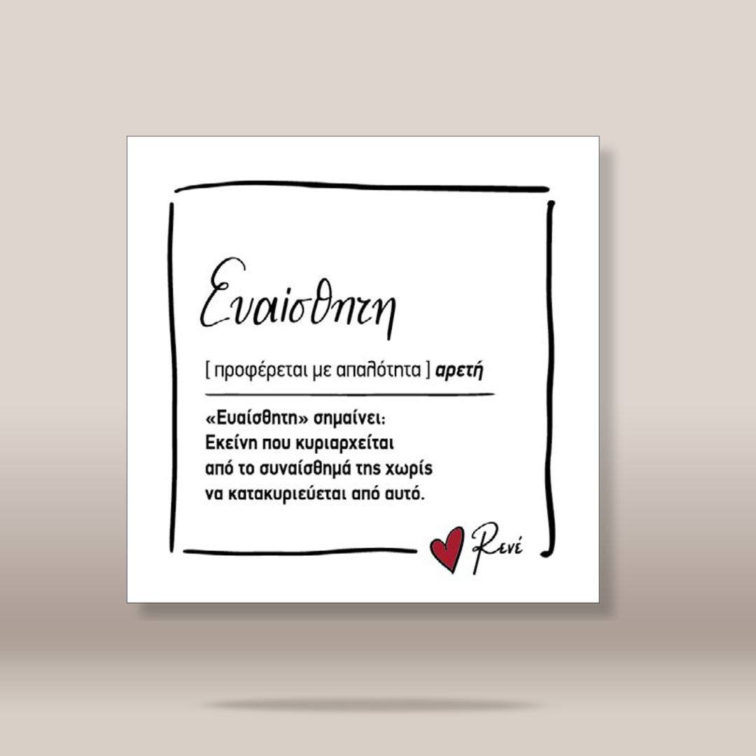 A square white art print or card with black Greek text and a small red heart, shown centered against a warm beige background with a soft shadow underneath.