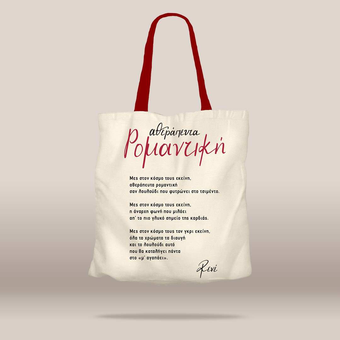 An off-white canvas tote bag with red handles, featuring Greek text printed on the front in black and red, set against a solid light gray background.