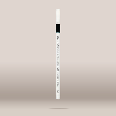 A single white cosmetic pen-style applicator with a black band near the top and printed text on the barrel, centered against a soft beige gradient background.