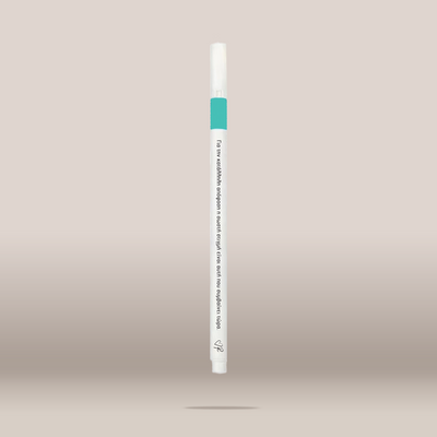 A single white cosmetic pen-style applicator with a teal band near the top and small black printed text, centered on a plain warm beige background.