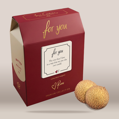 A red gift box of 'you're wonderful' collectible magnets by Rene, alongside two textured golden-brown cookies, set against a neutral light gray background.