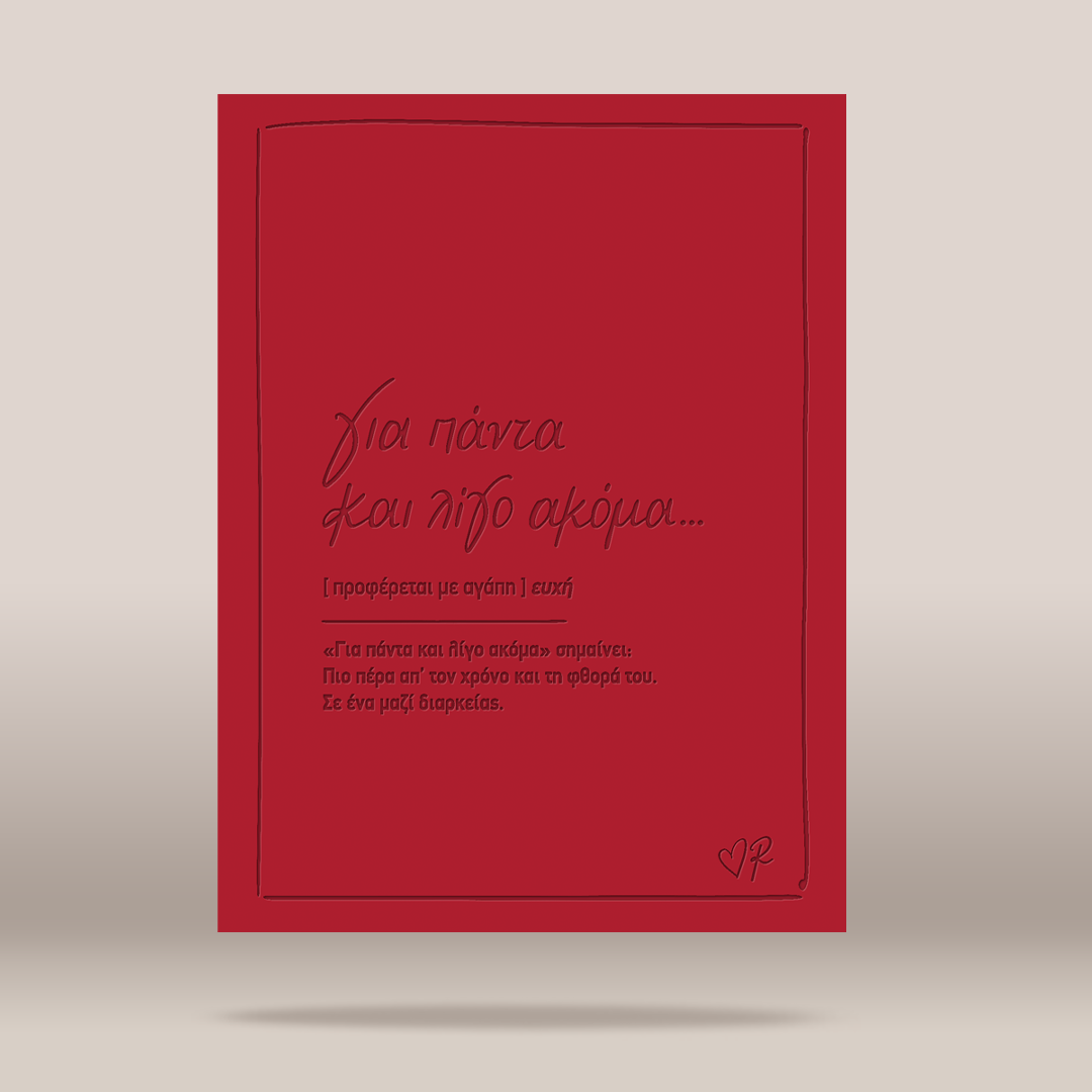 A red greeting card with black Greek text and a thin black border, shown standing upright against a neutral light gray background.