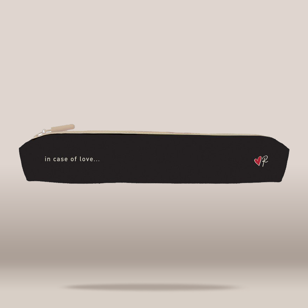 A black zippered pencil case with a cream zipper pull, featuring the white text 'in case of love.
