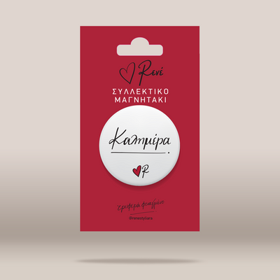 A white circular pin with the Greek text 'ΦηδειΤ' and a small red heart, mounted on a red backing card with Greek text and the brand name 'Rene'.
