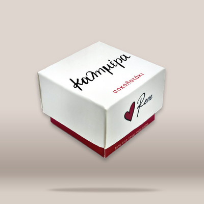 A white square gift box with red base and custom printed text and heart logo, shown floating on a light beige background.