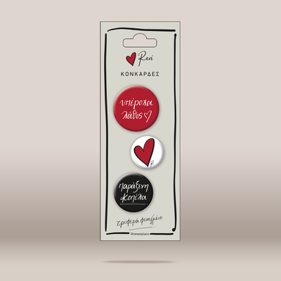 A vertical retail card holding three round pin-back style charms or stickers. The card has a hanger hole at the top and Greek text, including the brand name Rene