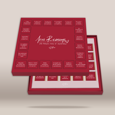 A red gift box set labeled 'Love Reasons 20 Föyos nou o ayétidou' with multiple small card or note compartments arranged on the lid and tray, photographed on a light beige background.