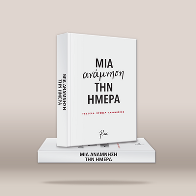 A white hardcover book titled 'ΜΙΑ ΑΝΑΜΝΗΣΗ ΤΗΝ ΗΜΕΡΑ' stands upright on top of a matching white book against a warm beige background. The upright book shows the front cover with black Greek text and a small red subtitle, while the spine is visible on the left.