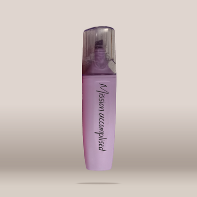 A lavender purple cosmetic bottle with a clear cap, featuring the text 'Vision accomplished' in black script, set against a neutral beige background.