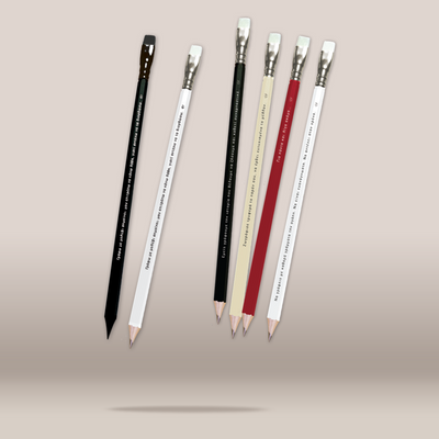 Six decorative pencils floating vertically against a plain beige background. The set includes black and white pencils, as well as beige, red, and white pencils, all with printed text and silver ferrules.