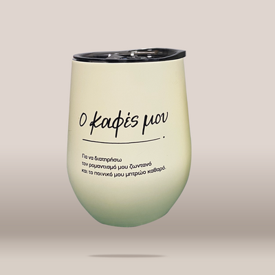 A stemless tumbler with a black lid, featuring a pale yellow-green gradient body with black Greek text, shown on a neutral beige background.