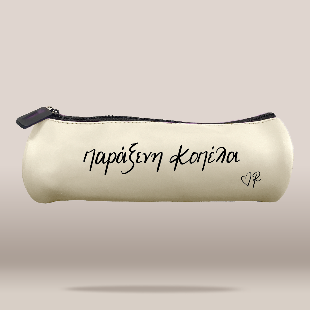 An off-white faux leather pencil case with black zipper trim and black printed Greek text 'ΠΑΡΑΞΕΝΗ ΚΟΠΕΛΑ' and a small heart monogram on a neutral beige background.