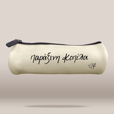 An off-white faux leather pencil case with black zipper trim and black printed Greek text 'ΠΑΡΑΞΕΝΗ ΚΟΠΕΛΑ' and a small heart monogram on a neutral beige background.
