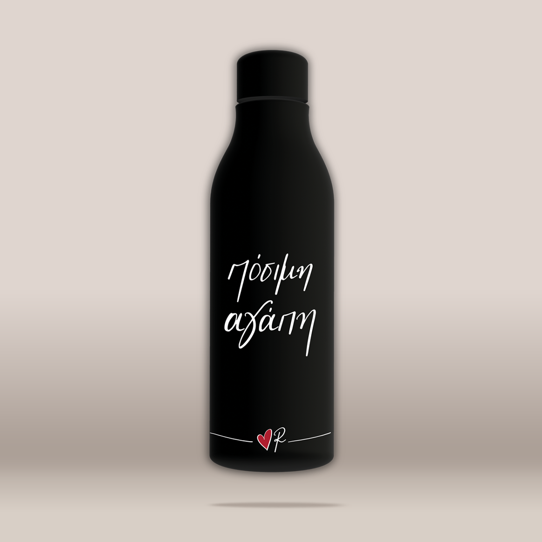 A matte black insulated bottle with a matching black cap, featuring white script text 'Πόσιμη Αγάπη' and a small red heart logo near the bottom, set against a neutral beige gradient background.