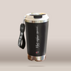A black insulated travel tumbler with a stainless steel lid and base, featuring a black wrist strap with white text. The tumbler is printed with white Greek script reading 'Μαζί πήγαμε παντού chic parrot.