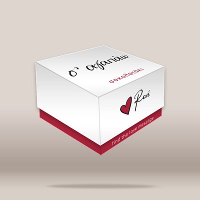 A white rectangular gift box with a red base, shown floating on a light beige gradient background. The top lid has black Greek text 'Σ΄ΑΓΑΠΑΩ' and red text 'ΣΟΚΟΛΑΤΑΚΙ', while the front side displays a red heart logo and the name 'Puri' in black script.