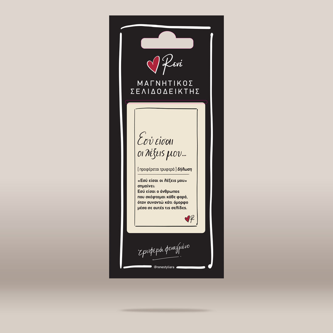A black hanging card package with Greek text and a cream label in the center, photographed against a plain warm beige background with a soft shadow underneath.
