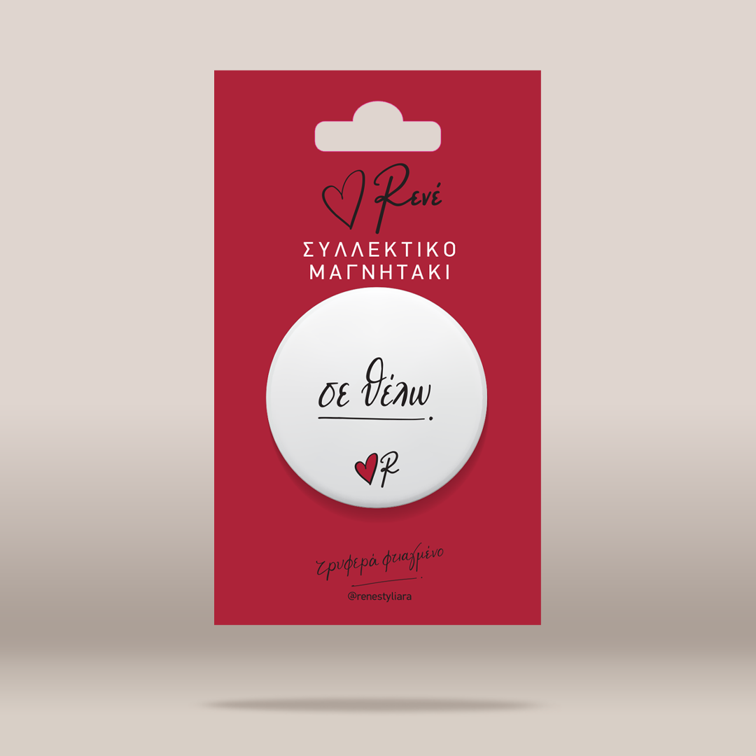 A white circular button badge with black script text and a small red heart logo, mounted on a red backing card with Greek text, shown on a light beige background.