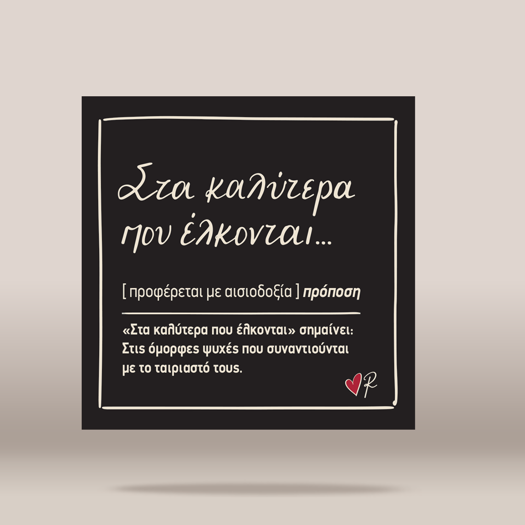 A square black sign or card with white Greek text and a thin white border, shown against a light warm gray background with a soft shadow underneath.