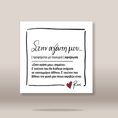 A square white art print or card with black Greek text, a hand-drawn black border, and a small red heart near the bottom right, shown against a warm beige gradient background.