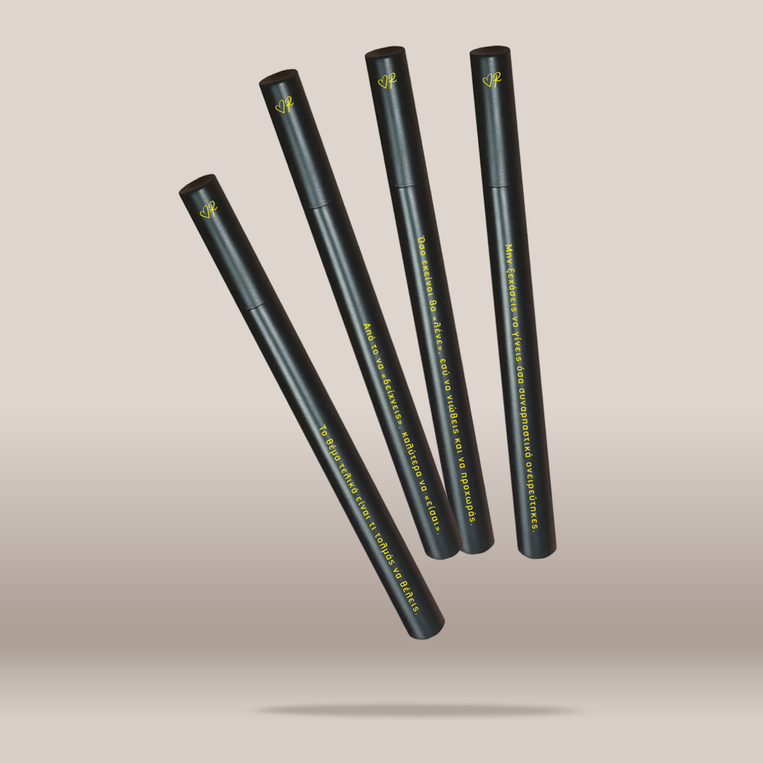 Four slim black cosmetic tubes arranged diagonally on a soft beige gradient background. Each tube has yellow text and a small yellow logo near the top.