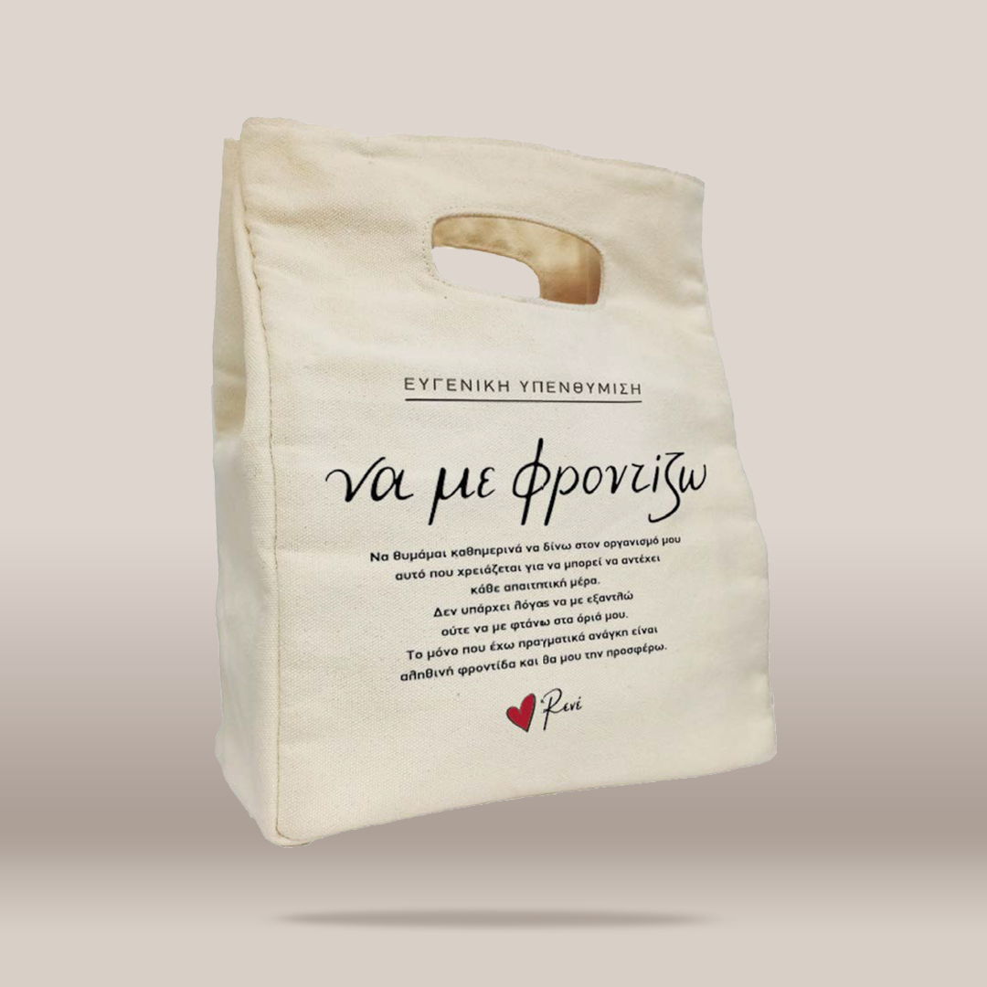An off-white canvas tote bag with a handle, featuring Greek text printed on the front and a small red heart logo with the name  at the bottom, shown against a solid beige background.