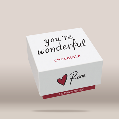 A white square chocolate box with printed text reading 'you're wonderful', 'chocolate', a red heart, and the name 'Rene' on a warm beige background.